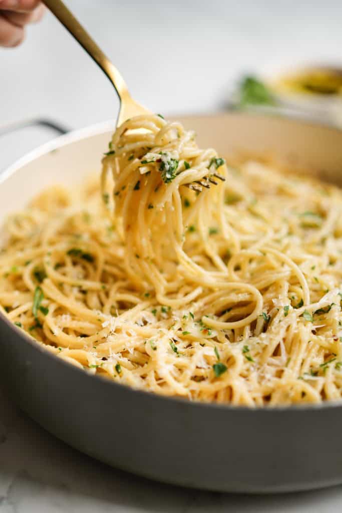 Lifting up strands of spaghetti with garlic and olive oil