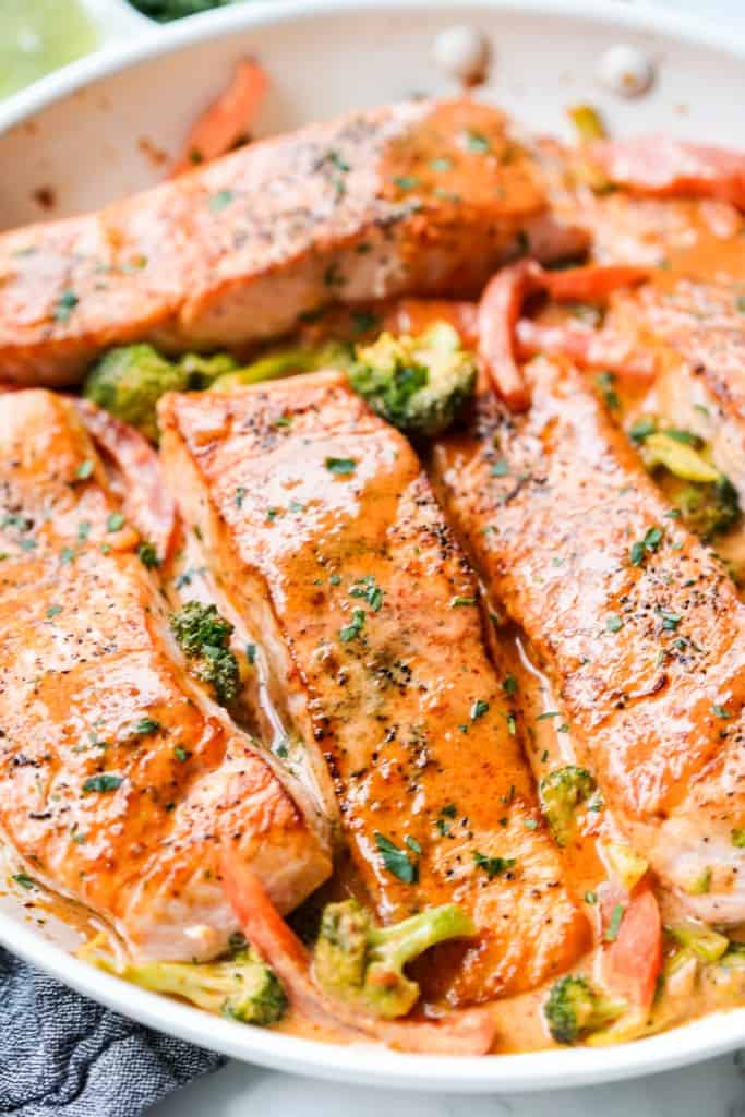 Salmon filets in Thai coconut curry sauce with broccoli and bell peppers.