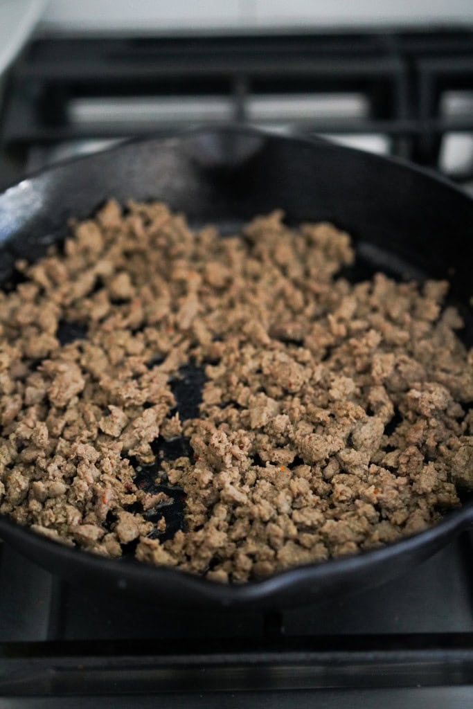 searing crumbled sausage in a skillet