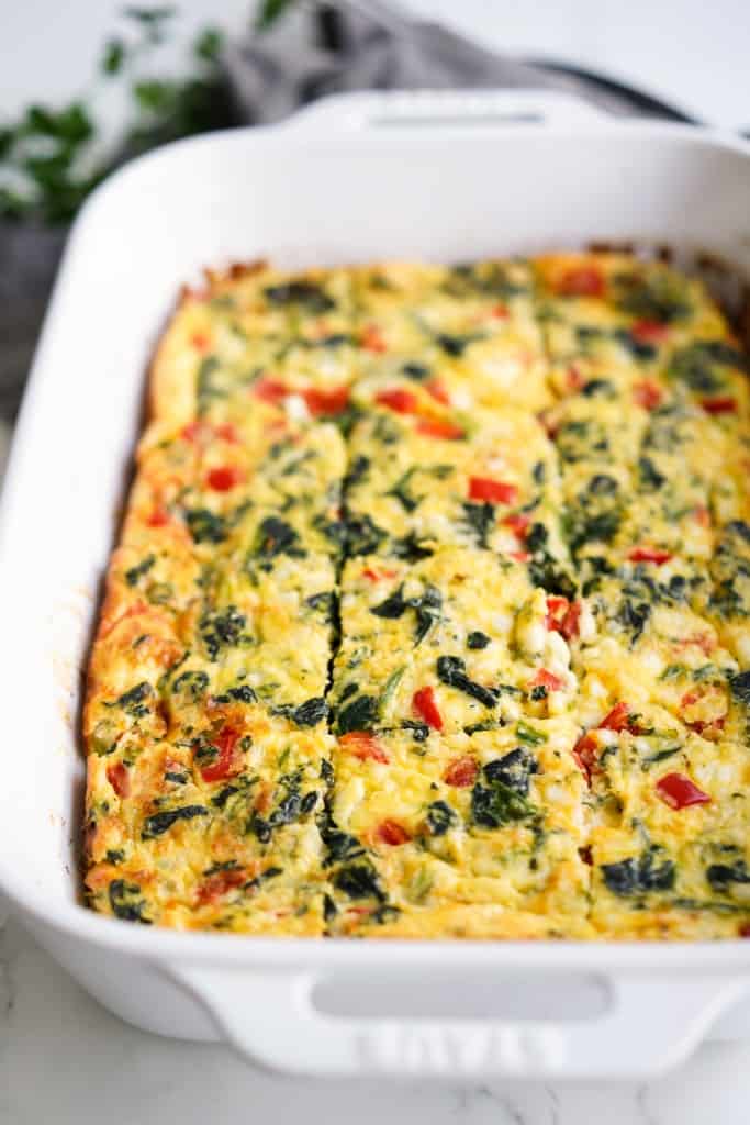 A large rectangular casserole of egg bake with cottage cheese sliced into square pieces