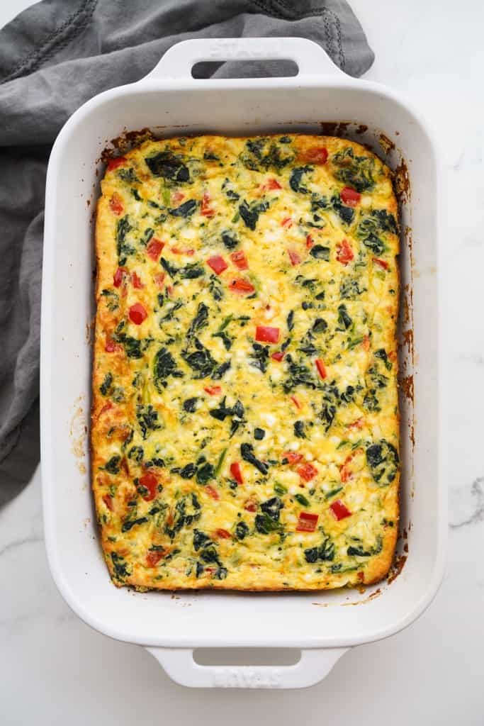 A top down view of an egg bake casserole filled with spinach, bell peppers and sausage