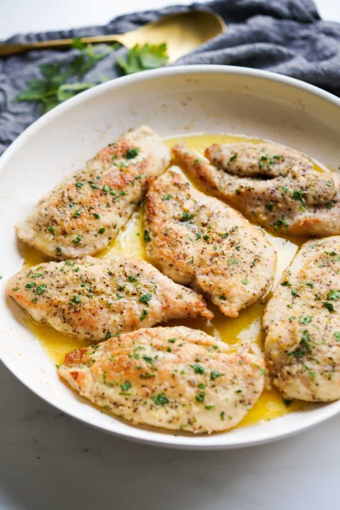 A skillet filled with chicken breast in garlic butter sauce