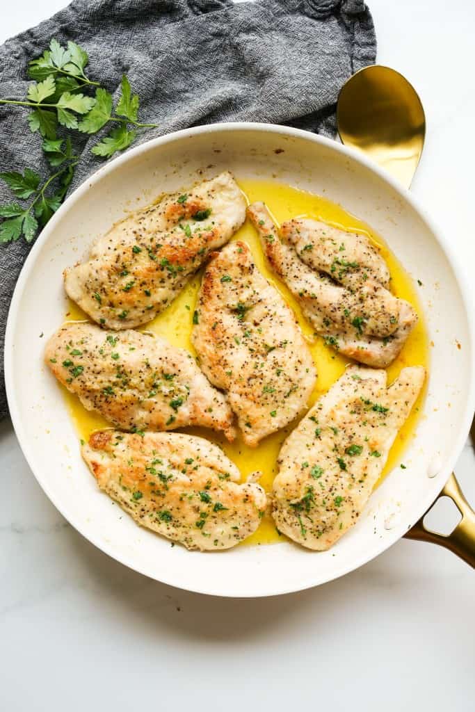 A skillet of garlic butter chicken breast in garlic butter sauce