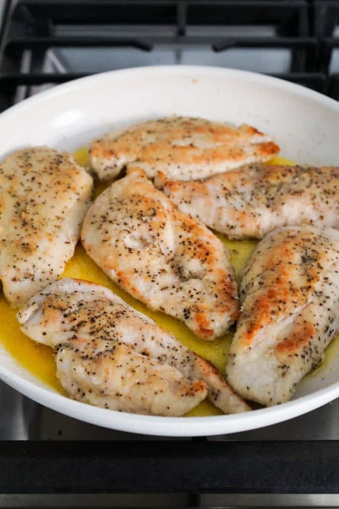 Bring seared chicken back into skillet with melted butter and garlic