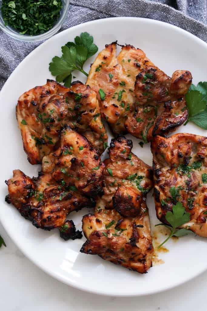 A plate loaded with charred teriyaki chicken thighs that is made in the air fryer