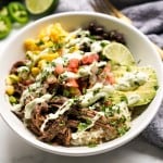 Beef burrito bowl along with corn, pico, avocado and drizzled with avocado crema