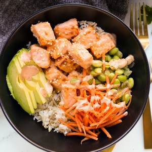 A bowl of air fryer salmon bites along with veggies and rice