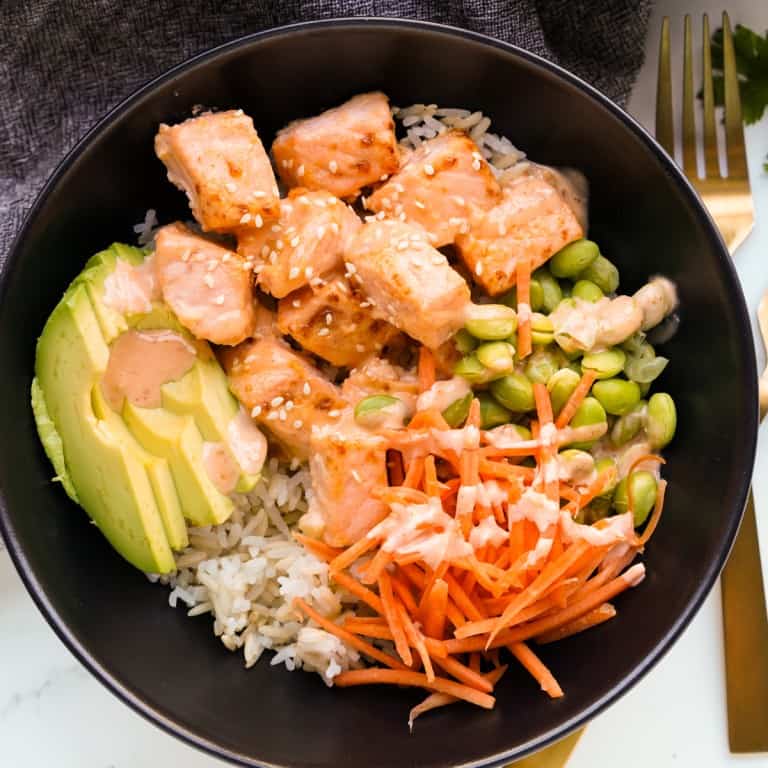 A bowl of air fryer salmon bites along with veggies and rice