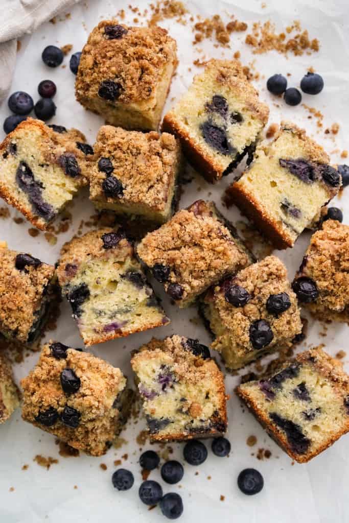 Square slices of blueberry coffee cake on a white parchment paper