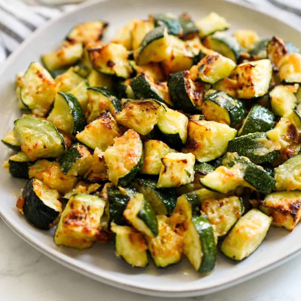 A round plate of diced zucchini that are crispy and golden brown on the outside