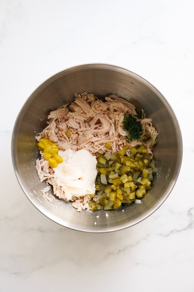 Canned chicken, mayo, mustard, chopped dill pickles and fresh dill in a mixing bowl