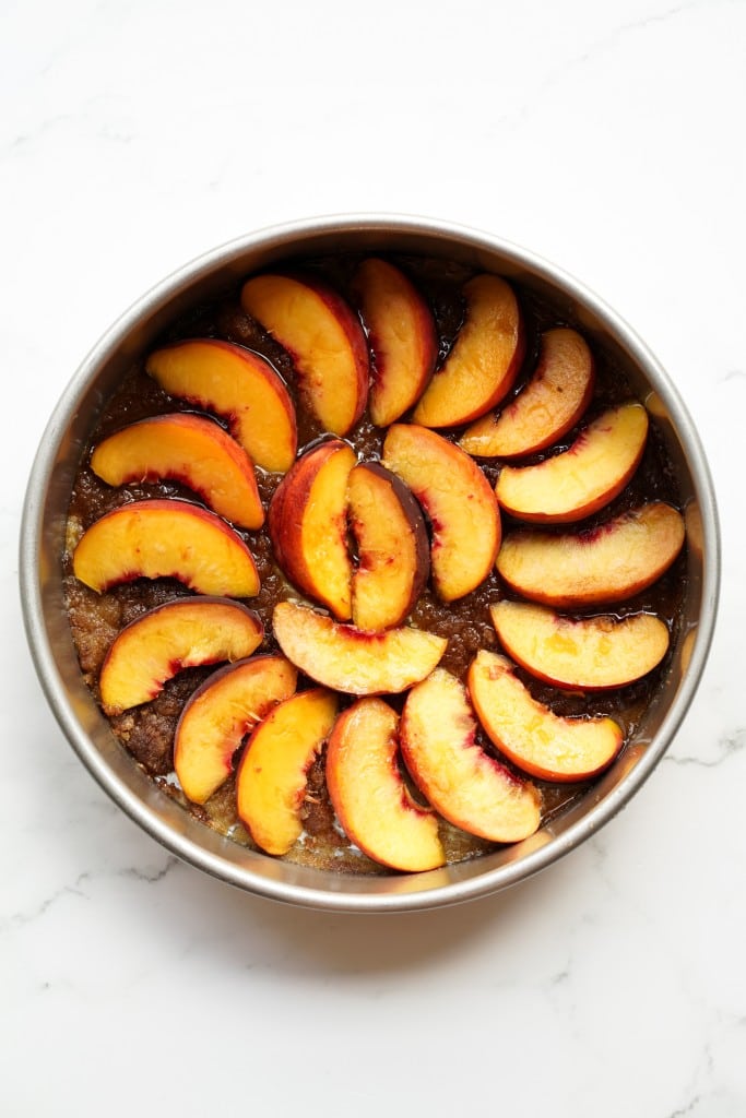 Arrangement of sliced peach in a round cake pan