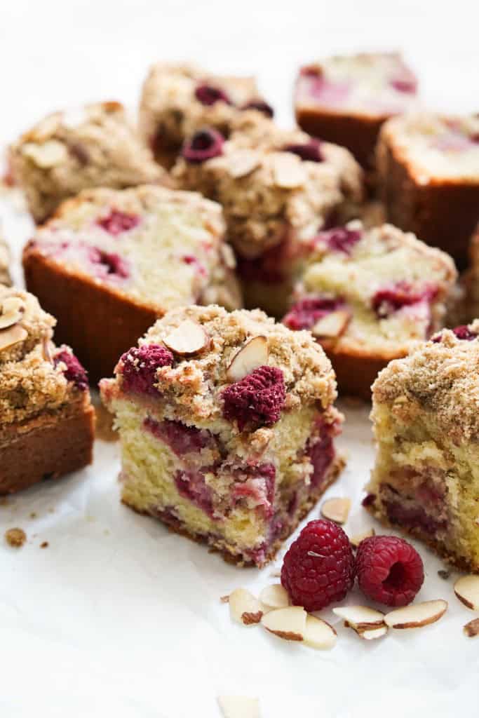 A small slice of raspberry almond coffee cake with a few more slices in the background