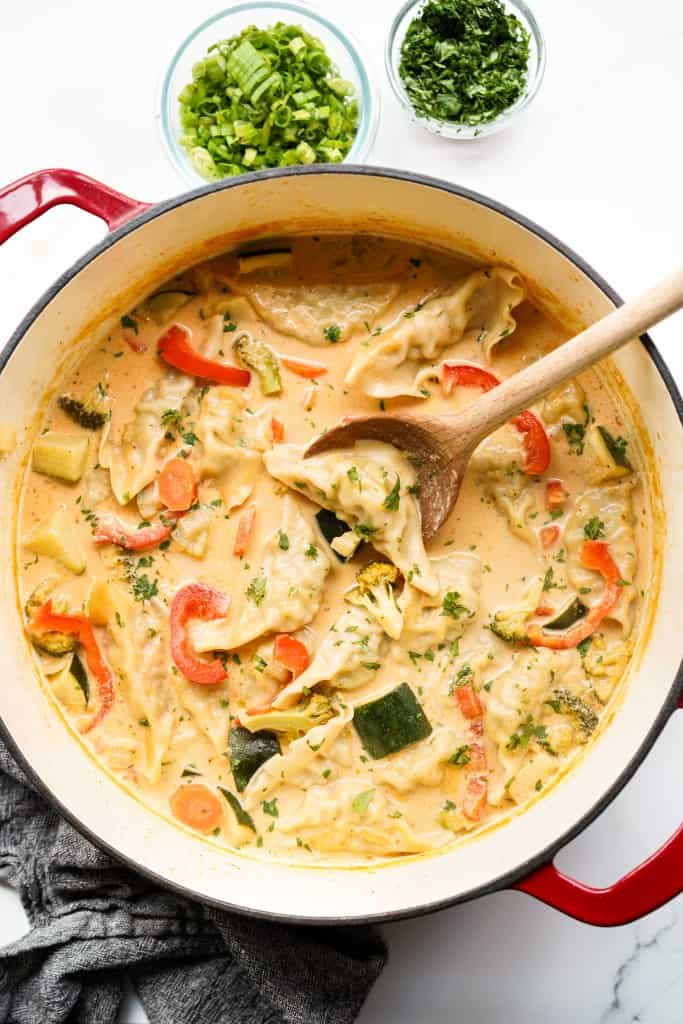 Dumplings in a red curry soup along with bell peppers, zucchini and carrots.
