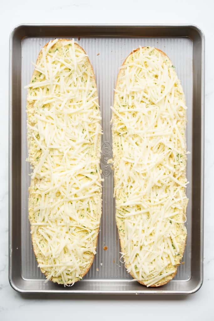 SHredded cheese on top of garlic bread