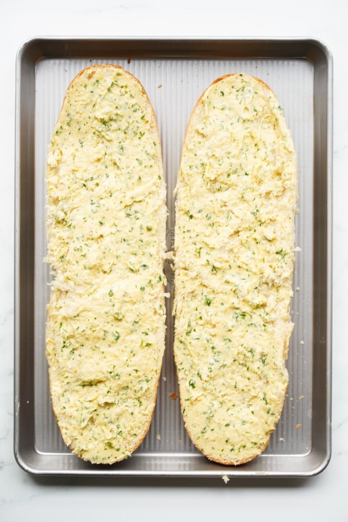 French loaf sliced into half and topped with garlic herb butter