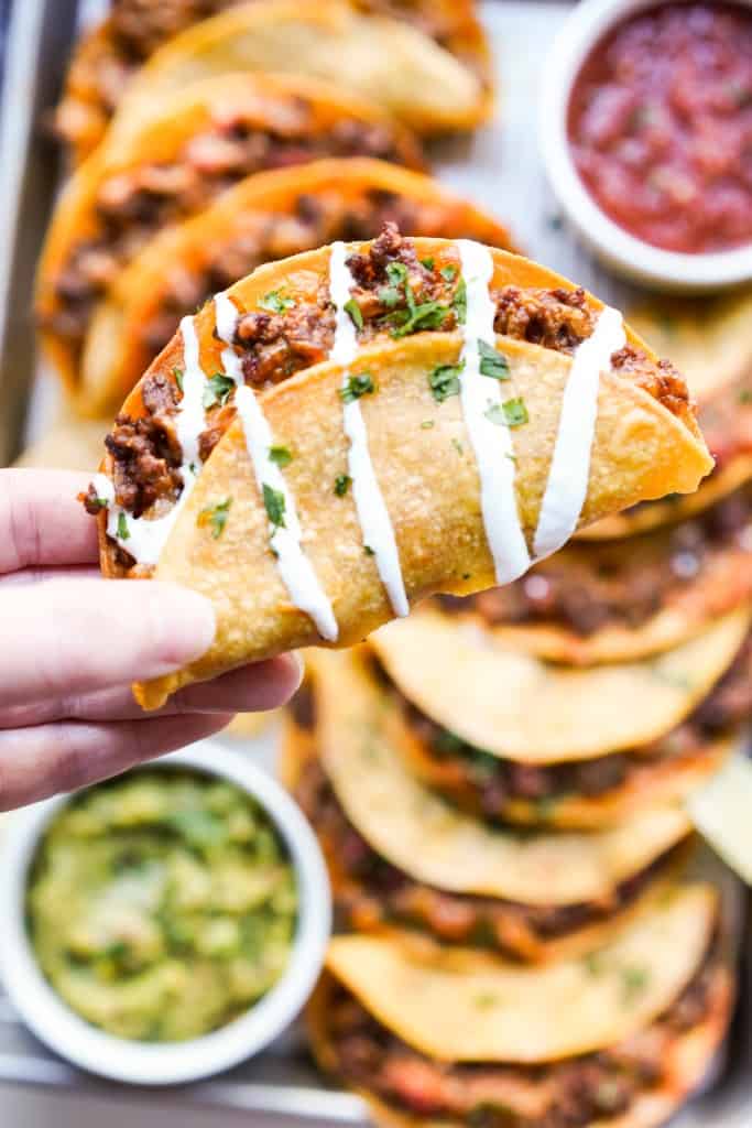 Picking up a beef taco in drizzled with sour cream