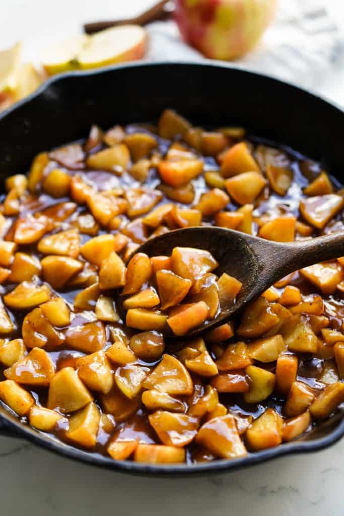 Caramelized apples in sticky brown sugar cinnamon glaze in cast iron skillet