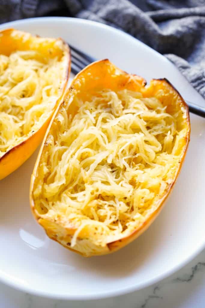 Two cooked spaghetti squash with fluffed tender thin strands