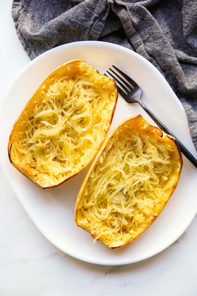 Two halves of baked spaghetti squashed on a platter