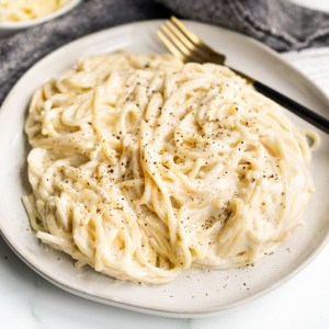 A plate of spaghetti mac and cheese topped with crack black pepper