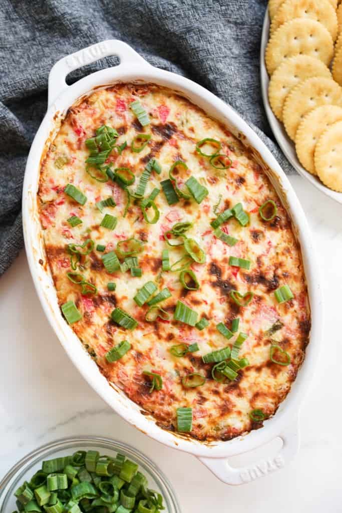 Top down viewed of crab rangoon dip after it is baked in the oven with a golden brown top crust and sprinkled with green onions