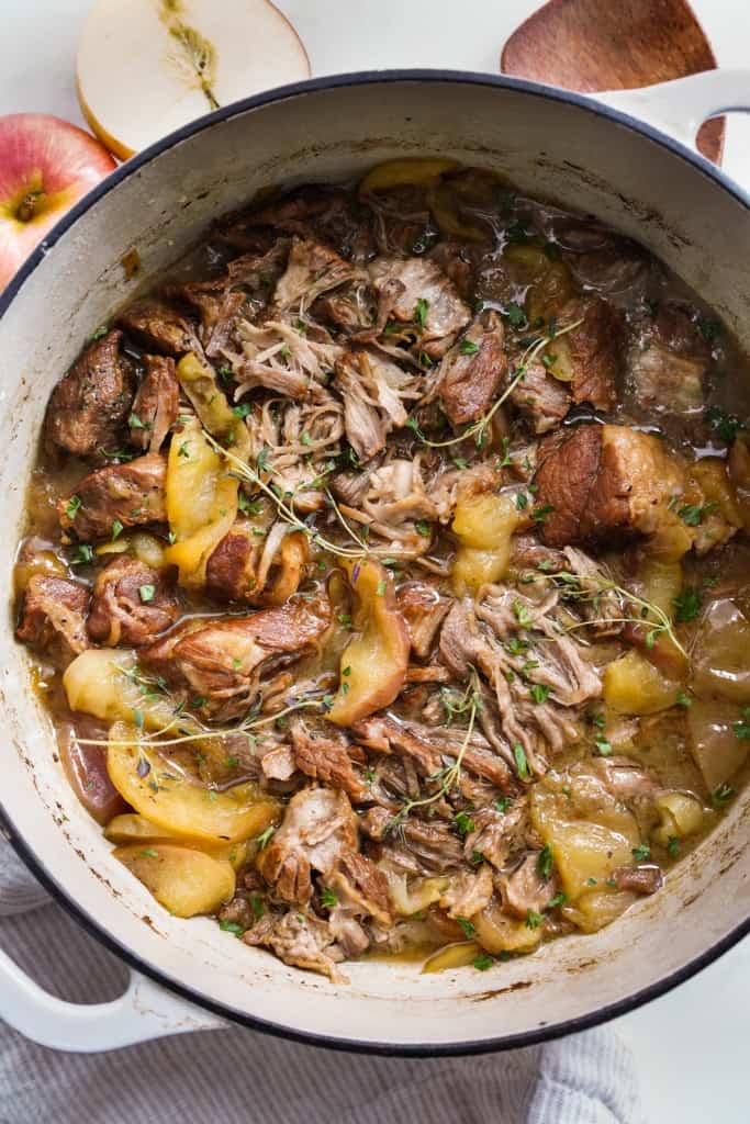 Top down view of a pot of shredded pork with cooked apples