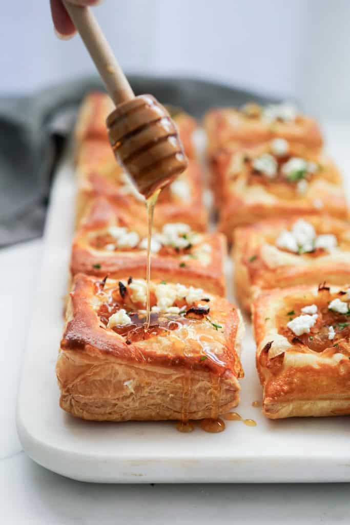 Drizzling Caramelized onion puff pastry with honey