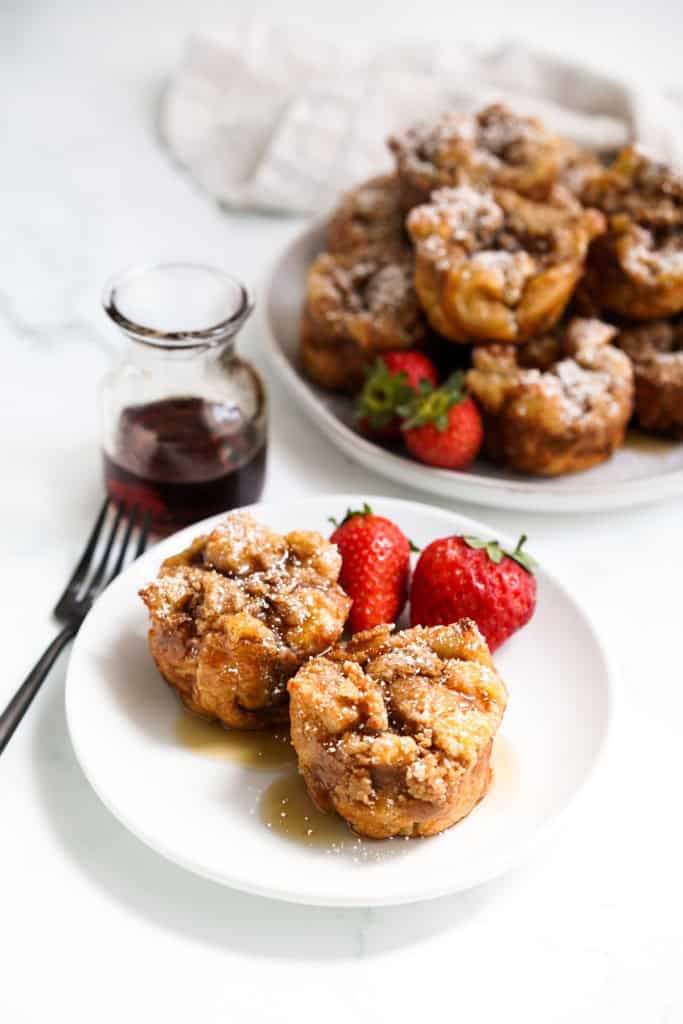 A small plate of two French toast muffins with strawberries.