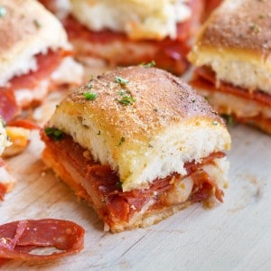 A zoomed in shot of a pizza slider that has pepperoni, mozzarella, and a perfectly browned top.