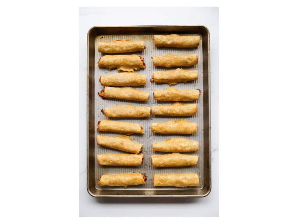 Sheet pan filled with crispy baked chicken taquitos straight out of the oven.