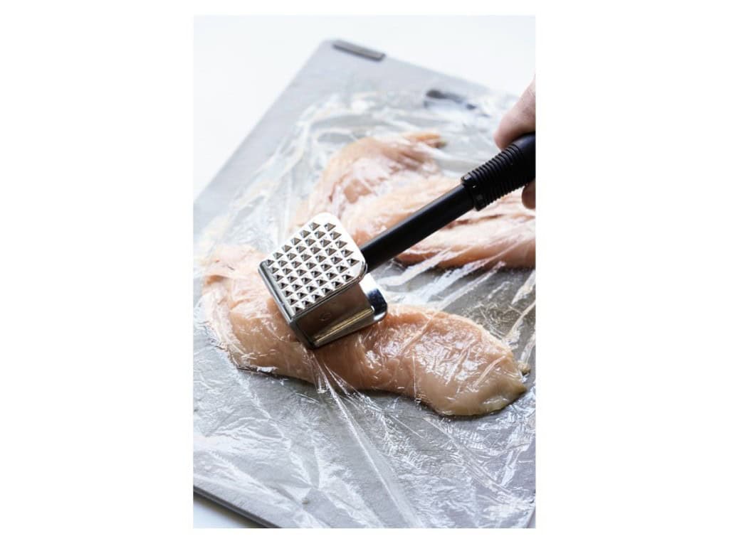 Pounding chicken using a meat tenderizer