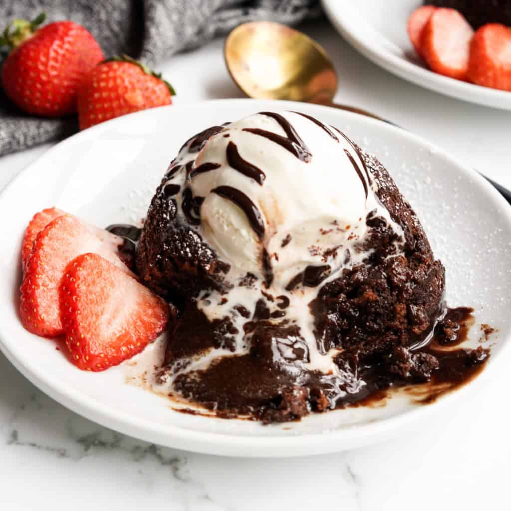 A close up shot of a chocolate lave cake that has been opened up showing its gooey chocolate center.