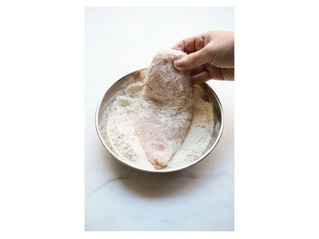 Coating chicken breast with flour