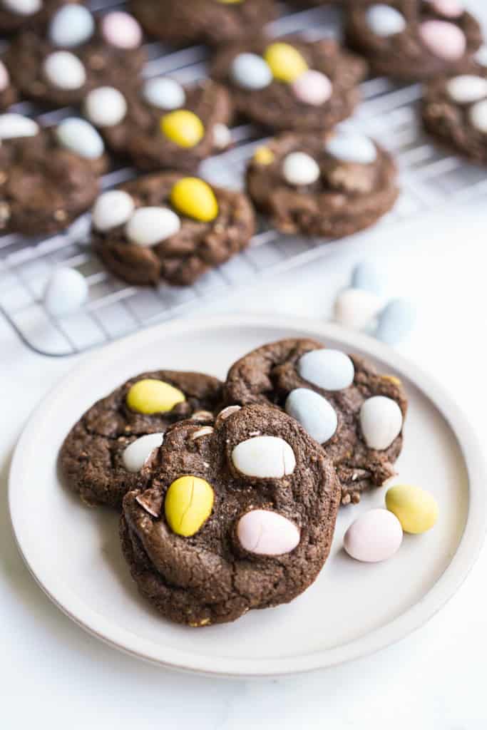 A small plate is filled with there chocolate Easter Egg cookies topped with Cadbury mini eggs.