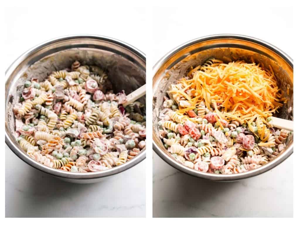 Shredded cheddar cheese is added to a mixing bowl filled with pasta, peas, cherry tomatoes, bacon, and red onions tossed in Ranch dressing.