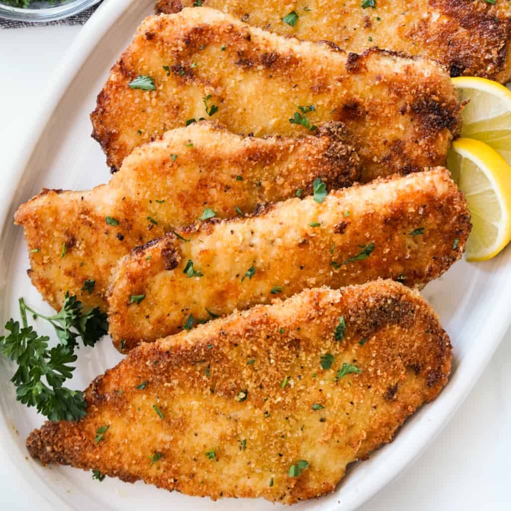 4-5 pieces of baked chicken cutlets that are crispy and golden brown