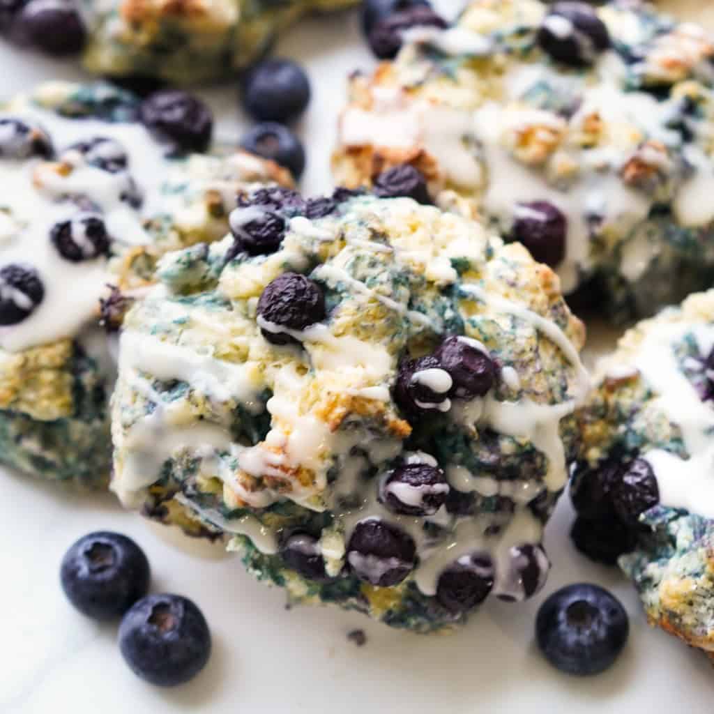 I close up picture showing plump blueberries in a Blueberry Biscuit topped with a vanilla icing.
