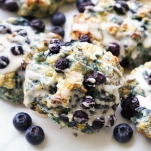 I close up picture showing plump blueberries in a Blueberry Biscuit topped with a vanilla icing.
