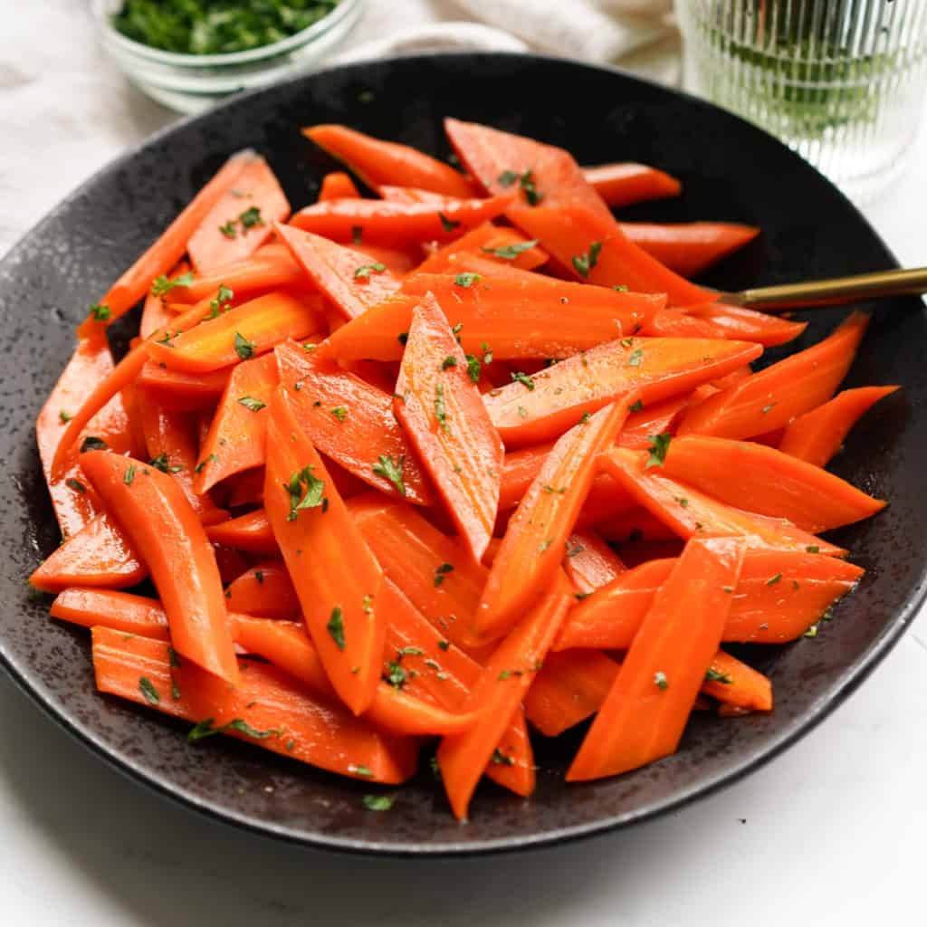 A bowl of brown sugar honey glazed candied carrots