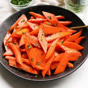 A bowl of brown sugar honey glazed candied carrots