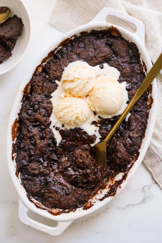 Hot Fudge Pudding Cake has been baked, cooled, and topped with vanilla ice cream.