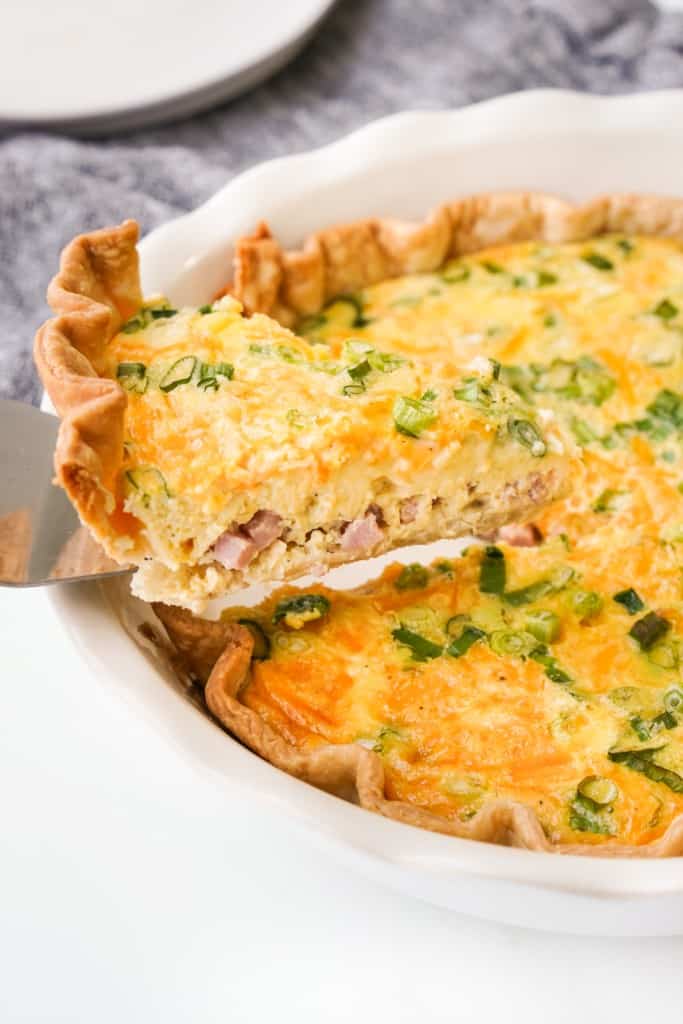 Diced ham, cheddar cheese, green onions, and fluffy eggs make up a lovely slice of Ham and Cheddar Cheese Quiche.