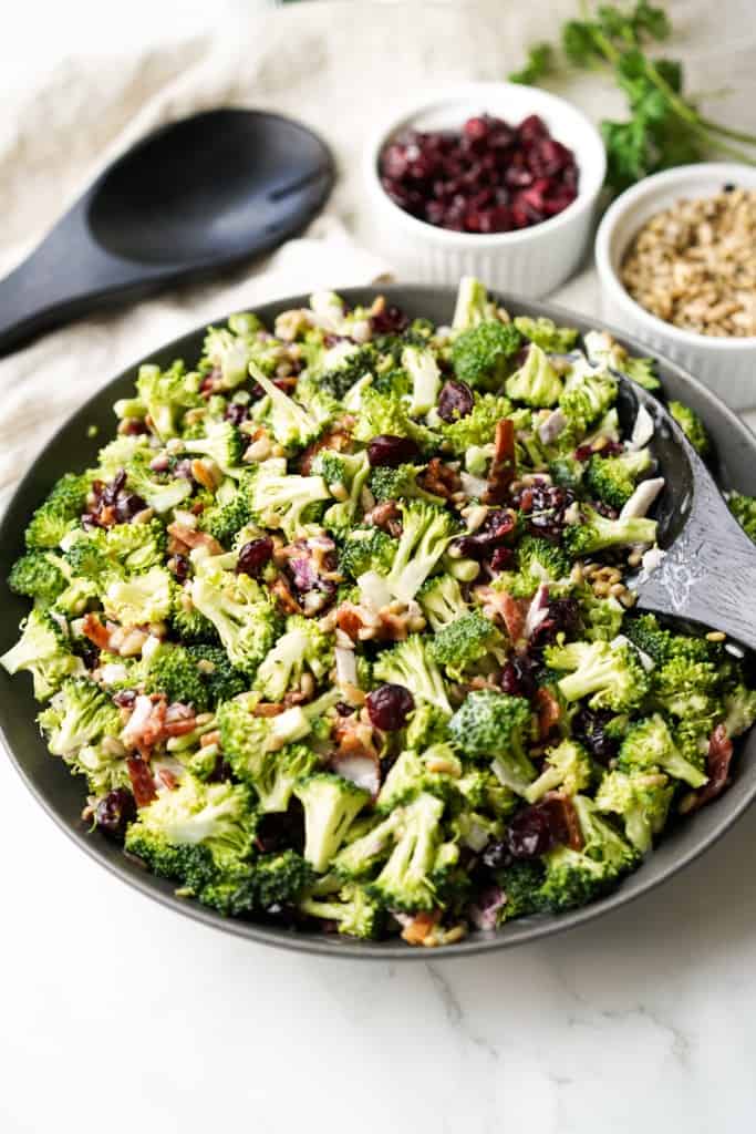 A black bowl is filled with fresh Broccoli Bacon Salad.