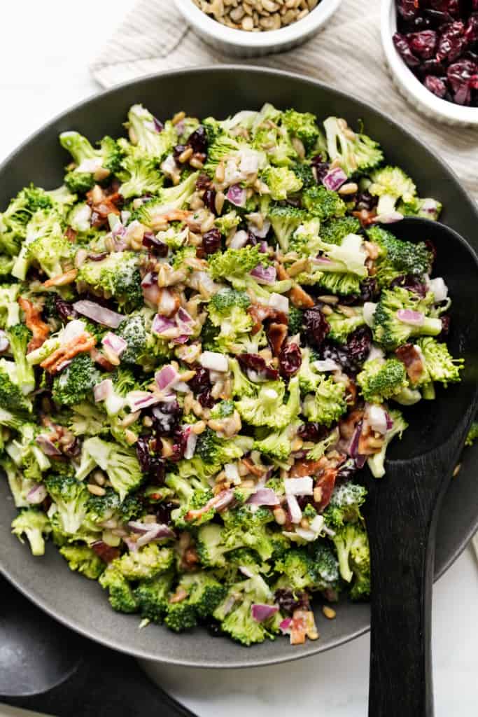 A black bowl is filled with a delicious and refreshing Broccoli Bacon Salad.