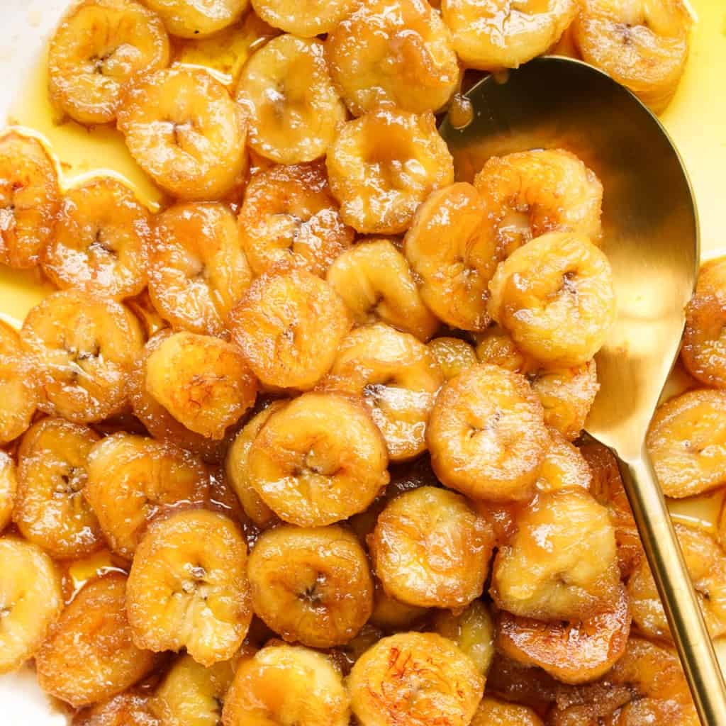 Close up shot of a spoon scooping up caramelized bananas.