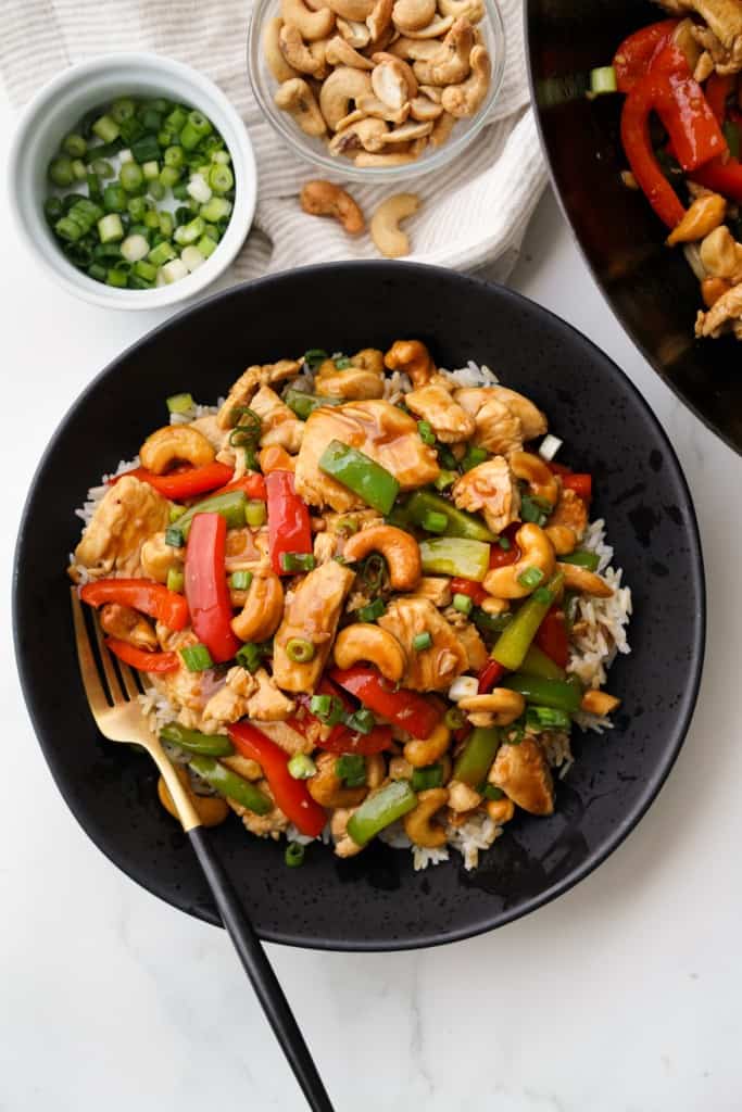 A top down picture of a bowl filled with white rice and colorful Cashew Chicken Stir Fry.
