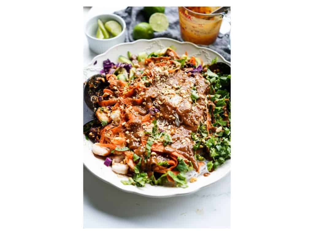 All of the salad ingredients have been topped with the dressing and are ready to be tossed together.