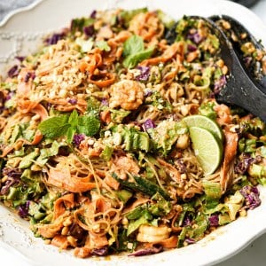 Close up picture of Spring Roll Salad that has cabbage, lettuce, noodles, cucumbers, carrots, peanuts, shrimp, and a lovely peanut butter sauce.
