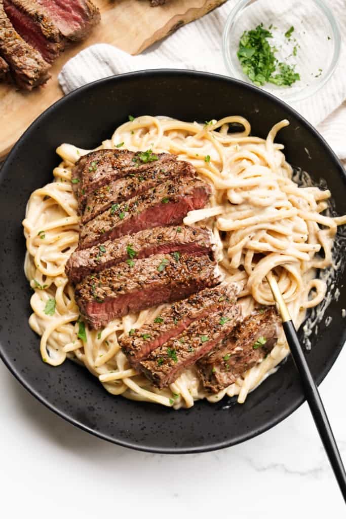 Creamy pasta is topped with perfectly cooked steak strips.
